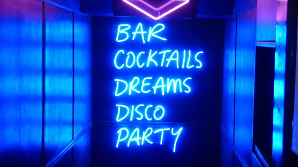 neon sign reading bar cocktails dreams disco party