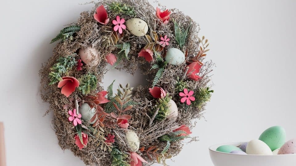 a wreath hanging on a wall next to a bowl of eggs